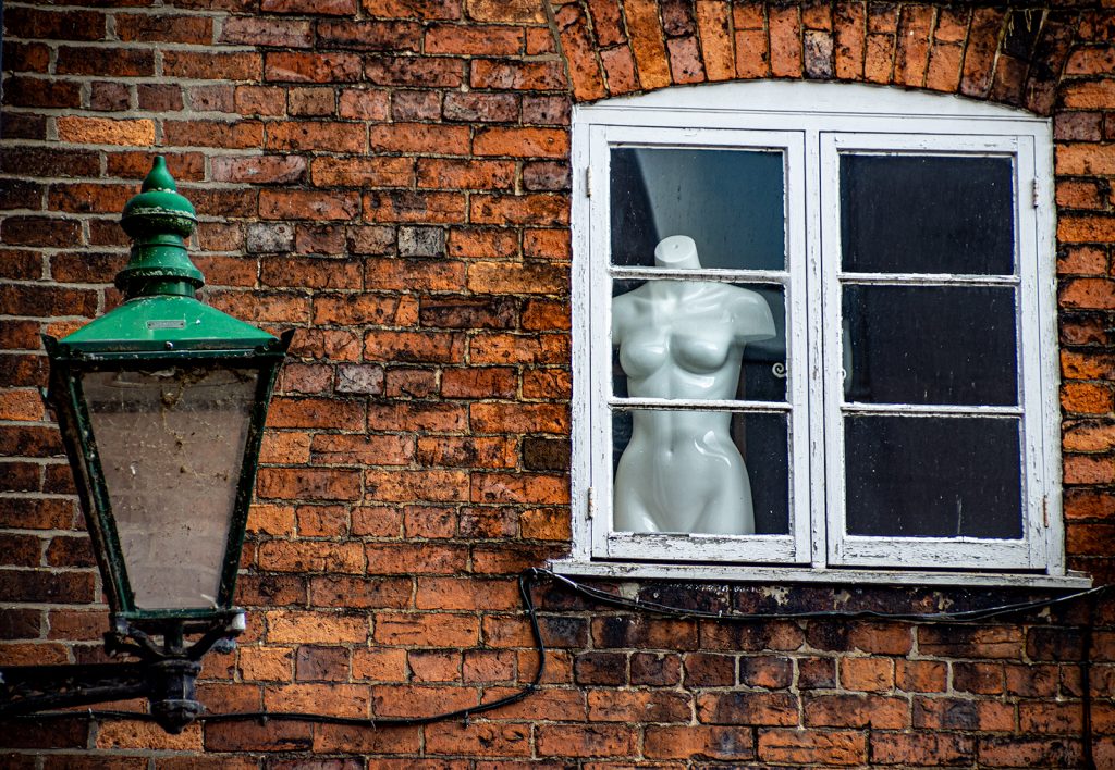 Model in a window with a green light outside
